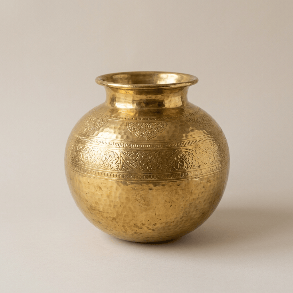 Hammered brass pot with floral and scroll engravings around the upper body
